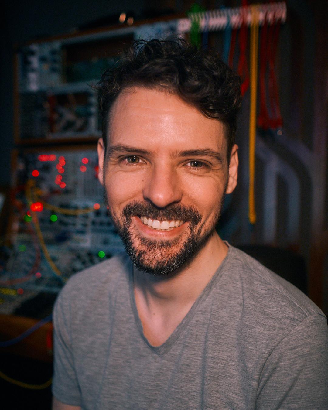 Adam in the studio, in front of a modular synthesiser.